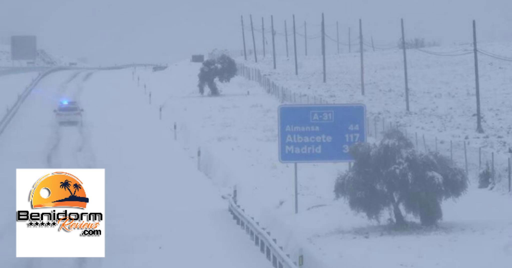 A solitary police car drives down a deluged A-31 tourist highway